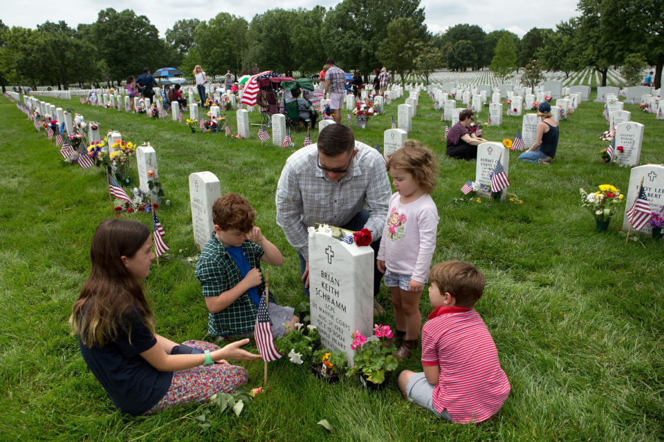 Major Clint Kappel and his children in Section 60, the burial ground for military personnel killed since 2001, at Arlington National Cemetery on May 30, 2016 in Arlington, Virginia.