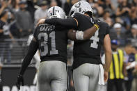 Las Vegas Raiders running back Peyton Barber (31) and quarterback Derek Carr (4) celebrate after Barber scored a touchdown against the Miami Dolphins during the second half of an NFL football game, Sunday, Sept. 26, 2021, in Las Vegas. (AP Photo/David Becker)