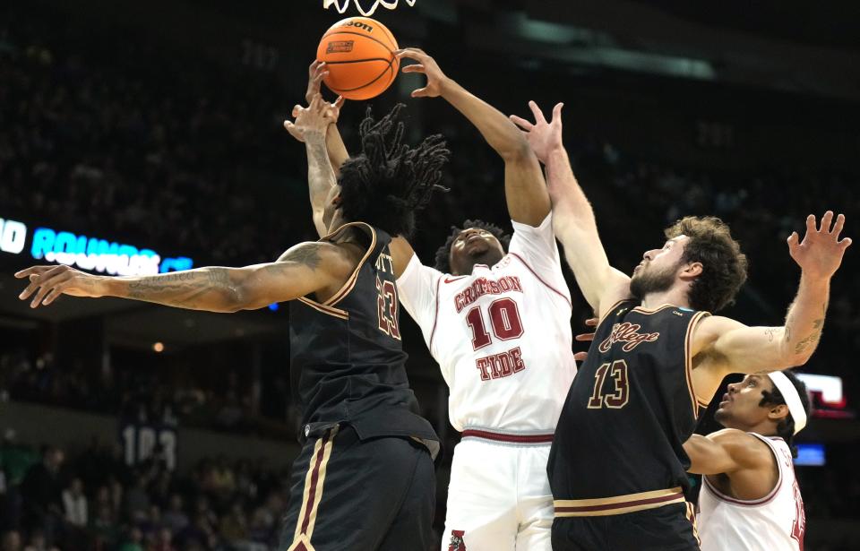 Mar 22, 2024; Spokane, WA, USA; Alabama Crimson Tide forward Mouhamed Dioubate (10) rebounds against Charleston Cougars forward James Scott (23) and forward Ben Burnham (13) during the first half in the first round of the 2024 NCAA Tournament at Spokane Veterans Memorial Arena. Mandatory Credit: Kirby Lee-USA TODAY Sports