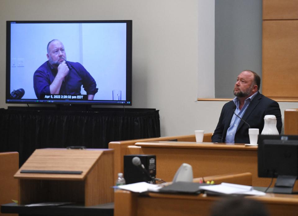 A man on the witness stand is shown a videotape of his deposition.
