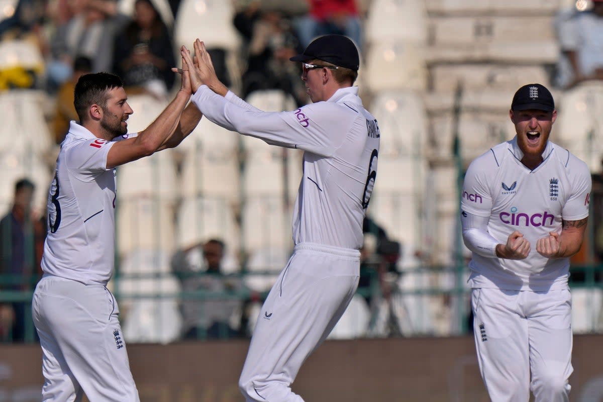 England’s Mark Wood, left, celebrates after taking a wicket (Anjum Naveed/AP) (AP)