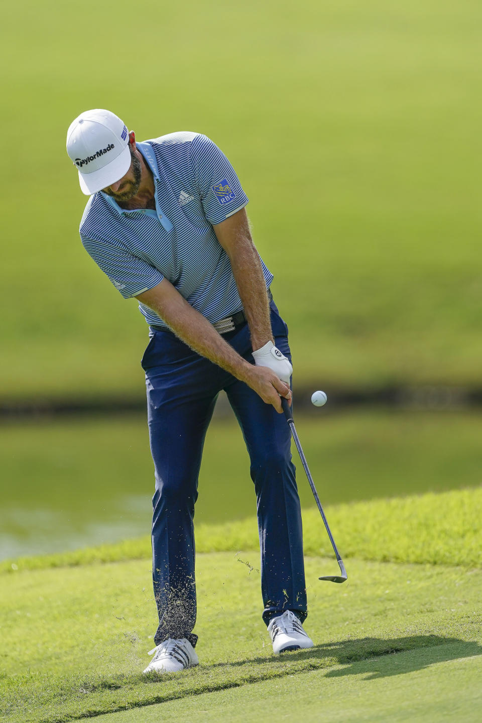 Dustin Johnson chips to the green on the 11th hole during the first round of the Tour Championship golf tournament at East Lake Golf Club in Atlanta, Friday, Sept. 4, 2020. (AP Photo/John Bazemore)