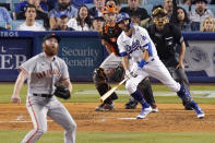 Los Angeles Dodgers' Chris Taylor, second from right, heads to first on a two-run home run while San Francisco Giants relief pitcher John Brebbia, left, watches long with catcher Buster Posey, second from left, and home plate umpire Dan Iassogna during the sixth inning of a baseball game Tuesday, July 20, 2021, in Los Angeles. (AP Photo/Mark J. Terrill)