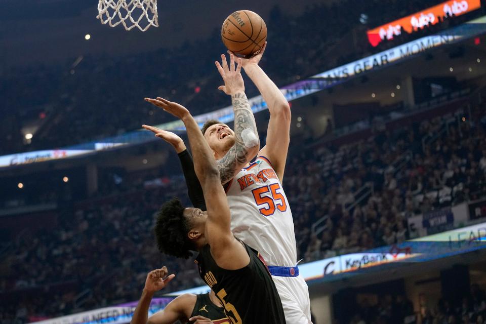 New York Knicks center Isaiah Hartenstein (55) shoots in front of Cleveland Cavaliers forward Isaac Okoro, left, in the first half of an NBA basketball game, Sunday, March 3, 2024, in Cleveland. (AP Photo/Sue Ogrocki)