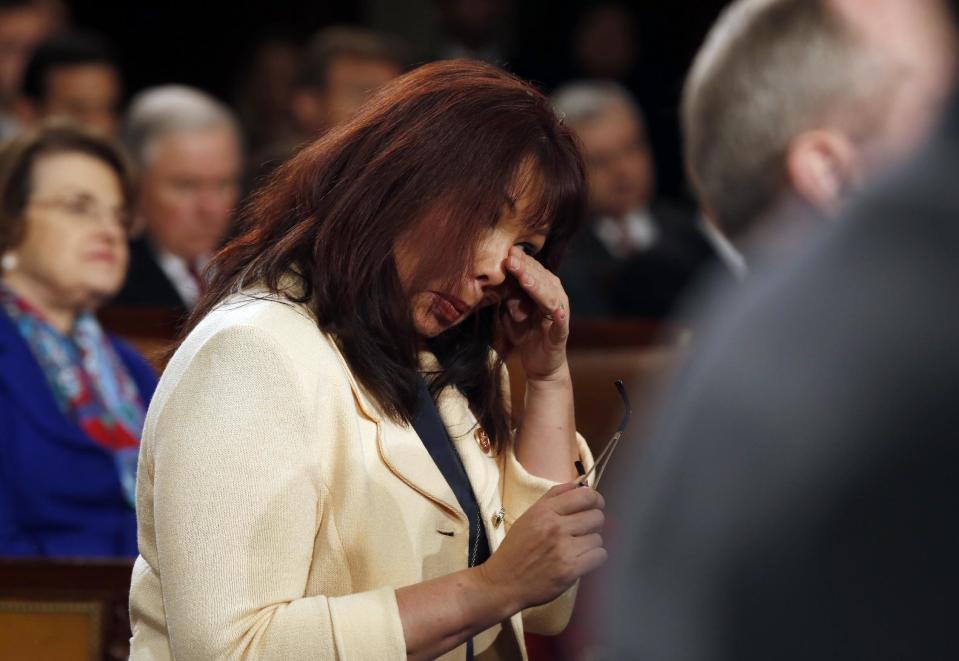 Rep Tammy Duckworth, D-Ill., wipes tears from her eyes during a standing ovation for Army Ranger Sgt. 1stt Class Cory Remsburg, who was recognized by President Barack Obama during the State of Union address before a joint session of Congress in the House chamber Tuesday, Jan. 28, 2014, in Washington. (AP Photo/Larry Downing, Pool)