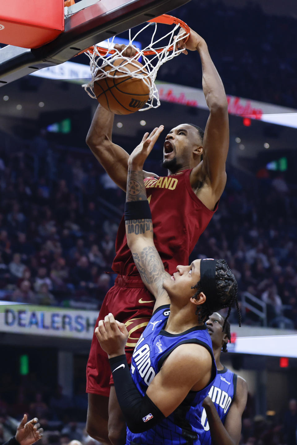 Cleveland Cavaliers forward Evan Mobley, top, dunks against Orlando Magic forward Paolo Banchero, bottom, during the first half of an NBA basketball game, Friday, Dec. 2, 2022, in Cleveland. (AP Photo/Ron Schwane)