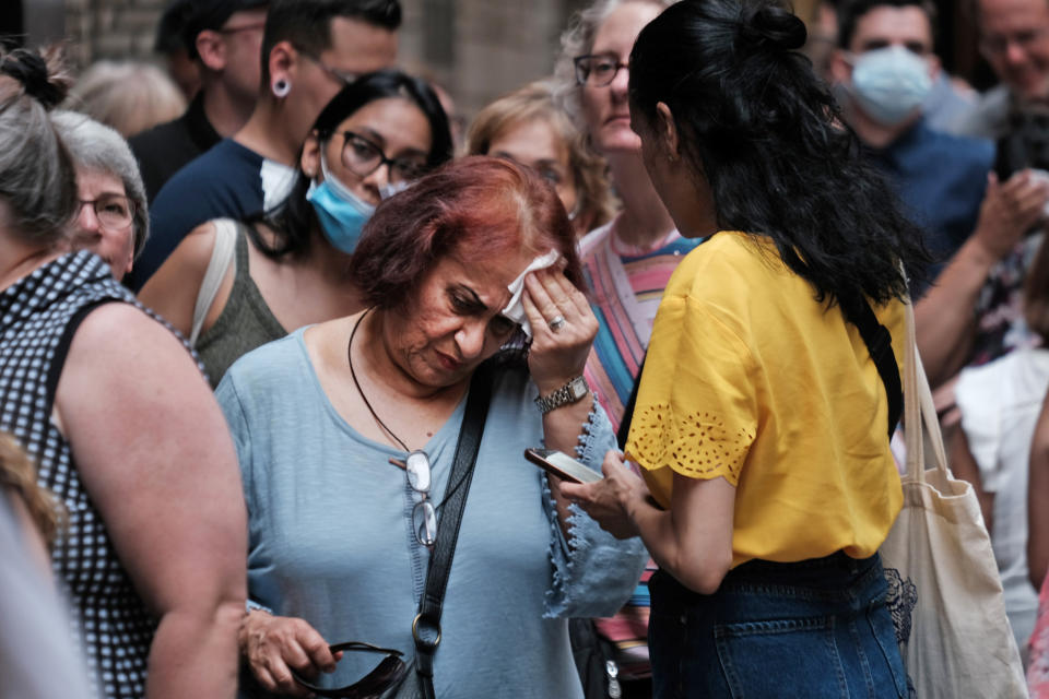 A woman wipes her brow as people wait in line in Midtown Manhattan during a heat wave on July 21, 2022. (Spencer Platt / Getty Images file)