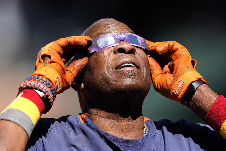 Houston Astros manager Dusty Baker Jr. uses protective glasses to look at the solor eclipse during the team's baseball practice in Houston, Saturday, Oct. 14, 2023. The Astros are scheduled to play the Texas Rangers in Game 1 of baseball's American League Championship Series on Sunday. (AP Photo/Tony Gutierrez)