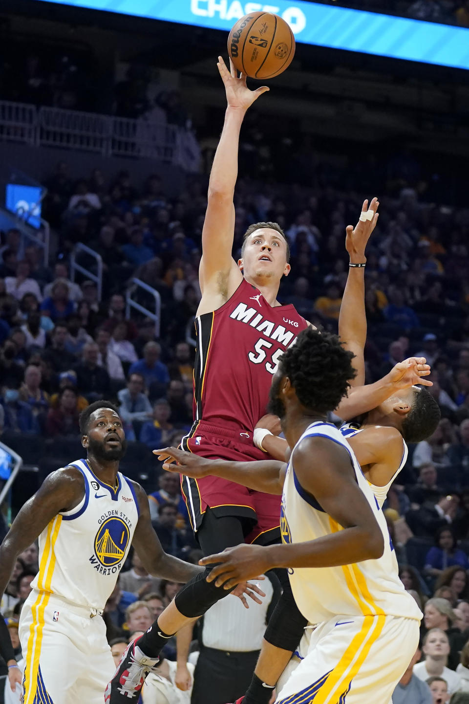 Miami Heat guard Duncan Robinson, top, shoots between Golden State Warriors forward JaMychal Green (1), guard Jordan Poole, right, and forward Andrew Wiggins during the first half of an NBA basketball game in San Francisco, Thursday, Oct. 27, 2022. (AP Photo/Jeff Chiu)
