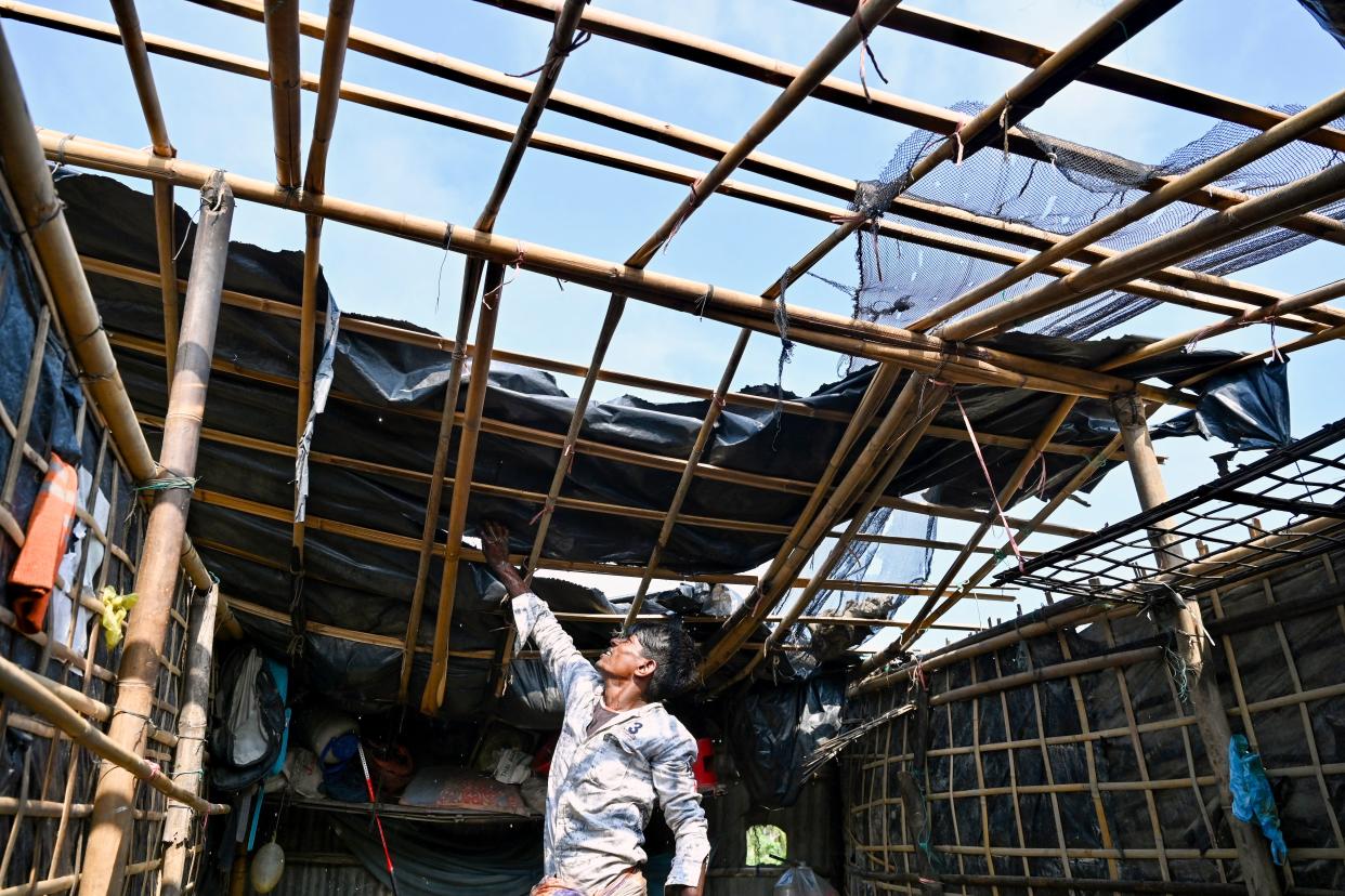 A man surveys the roof of a house damaged by Cyclone Mocha on Shahpori Island in Bangladesh on Monday. 