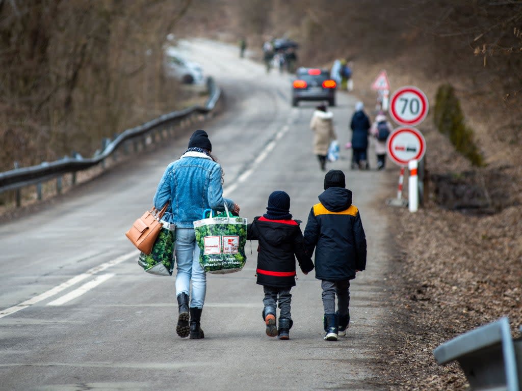 A woman with two children after crossing the Slovak-Ukrainian border in Ubla, eastern Slovakia on 25 February, 2022  (Getty)