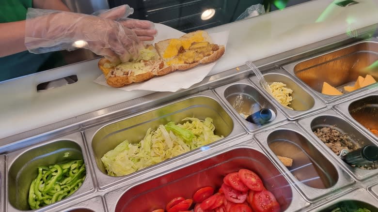 Employee making a sub sandwich