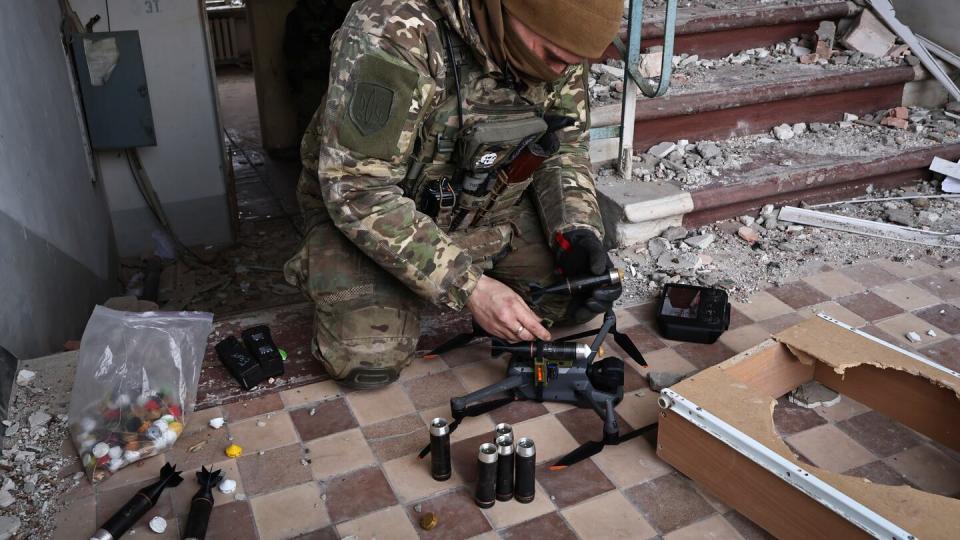 A Ukrainian soldier equips a drone with grenades in the area of the heaviest battles with the Russian invaders in Bakhmut March 15. (Roman Chop/AP)