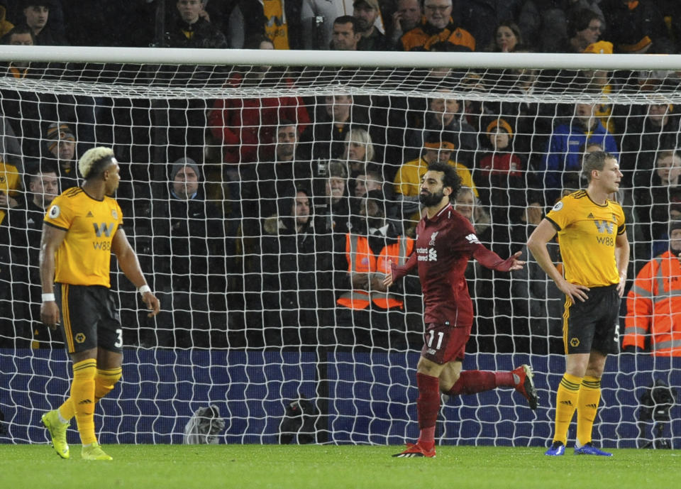 Liverpool's Mohamed Salah, centre, celebrates after scoring his side's opening goal during the English Premier League soccer match between Wolverhampton Wanderers and Liverpool at the Molineux Stadium in Wolverhampton, England, Friday, Dec. 21, 2018. (AP Photo/Rui Vieira)