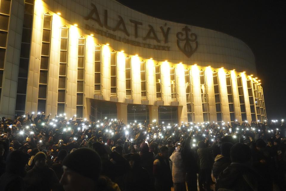 FILE - Protesters light by their smartphones as they gather in the center of Almaty, Kazakhstan, Tuesday, Jan. 4, 2022. The gatherings were initially peaceful, but over the course of a week, groups of armed men appeared in Almaty, some seen riding in cars without license plates or with their faces covered. Participants of peaceful marches told the AP at the time that these men had urged them to storm government buildings, promising to give them guns. (Vladimir Tretyakov/NUR.KZ via AP, File)