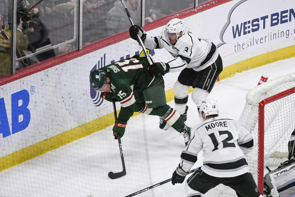 Los Angeles Kings defenseman Matt Roy (3) checks Minnesota Wild center Mason Shaw (15) into the boards during the third period of an NHL hockey game Tuesday, Feb. 21, 2023, in St. Paul, Minn. Minnesota won 2-1. (AP Photo/Craig Lassig)