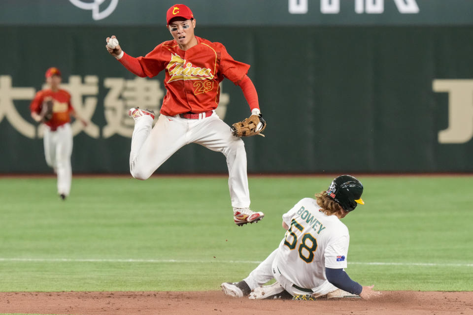 Luo Jinjun of China catches the ball as Jake Bowey of Australia slides into second base during their Pool B game at the World Baseball Classic at the Tokyo Dome, Japan, Saturday, March 11, 2023. (AP Photo/Eugene Hoshiko)