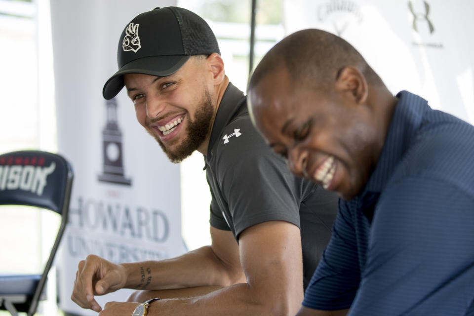 CORRECTS TO PRESIDENT, NOT INTERIM PRESIDENT AS ORIGINALLY SENT - Golden State Warriors guard Stephen Curry, left, and Howard University president Wayne Frederick laugh before a news conference at Langston Golf Course in Washington, Monday, Aug. 19, 2019, where Curry announced that he would be sponsoring men's and women's golf teams at Howard University. (AP Photo/Andrew Harnik)