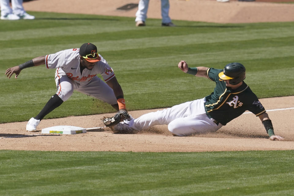 Oakland Athletics' Sean Murphy, right, is tagged out trying to advance to third base by Baltimore Orioles third baseman Maikel Franco, left, during the seventh inning of a baseball game in Oakland, Calif., Sunday, May 2, 2021. (AP Photo/Jeff Chiu)