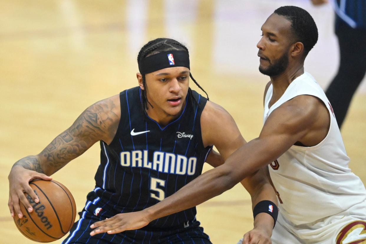 Orlando Magic forward Paolo Banchero drives against Cavaliers forward Evan Mobley in the first quarter, Feb. 22, 2024, in Cleveland.