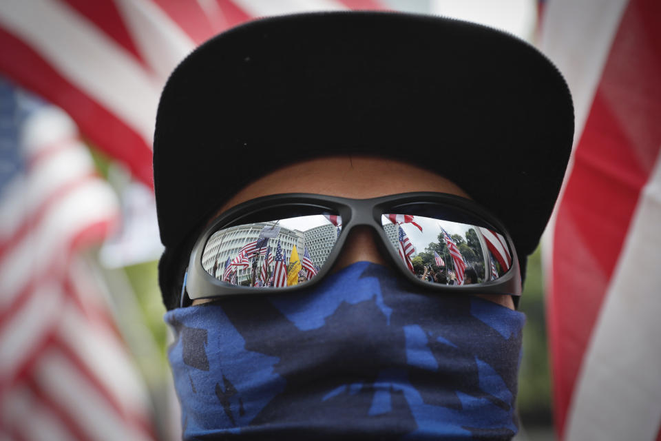 United States flags are reflected on glasses of a protester during a protest in Hong Kong, Sunday, Sept. 8, 2019. Demonstrators in Hong Kong plan to march to the U.S. Consulate on Sunday to drum up international support for their protest movement, a day after attempts to disrupt transportation to the airport were thwarted by police. (AP Photo/Kin Cheung)