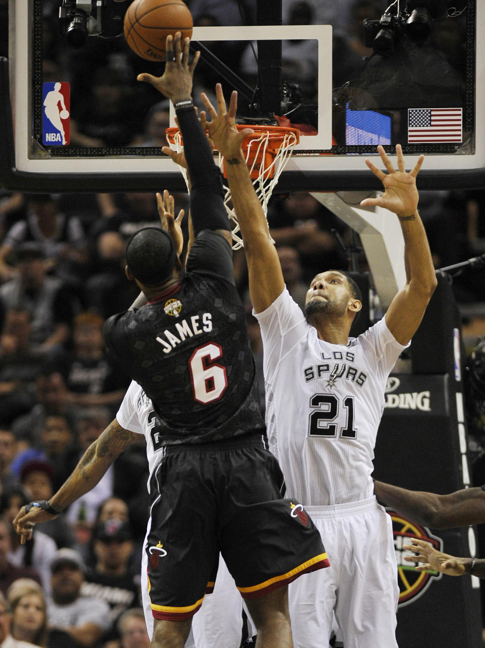 San Antonio Spurs forward Tim Duncan, right, defends Miami Heat forward LeBron James during the first half of an NBA basketball game on Thursday, March 6, 2014, in San Antonio. (AP Photo/Darren Abate)