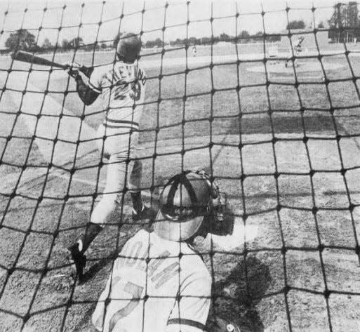 MARCH 23, 1982: Joe Nolan wears the catching gear while the guy who is replacing him as the Reds' regular catcher, Alex Trevino, takes his swings in the batting cage in Tampa.