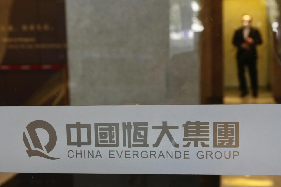 A security guard stands on duty at the headquarters of China Evergrande Group in Hong Kong, Monday, Oct. 4, 2021. Shares in troubled real estate developer China Evergrande Group and its property management unit Evergrande Property Services were suspended from trading Monday in Hong Kong. (AP Photo/Vincent Yu)