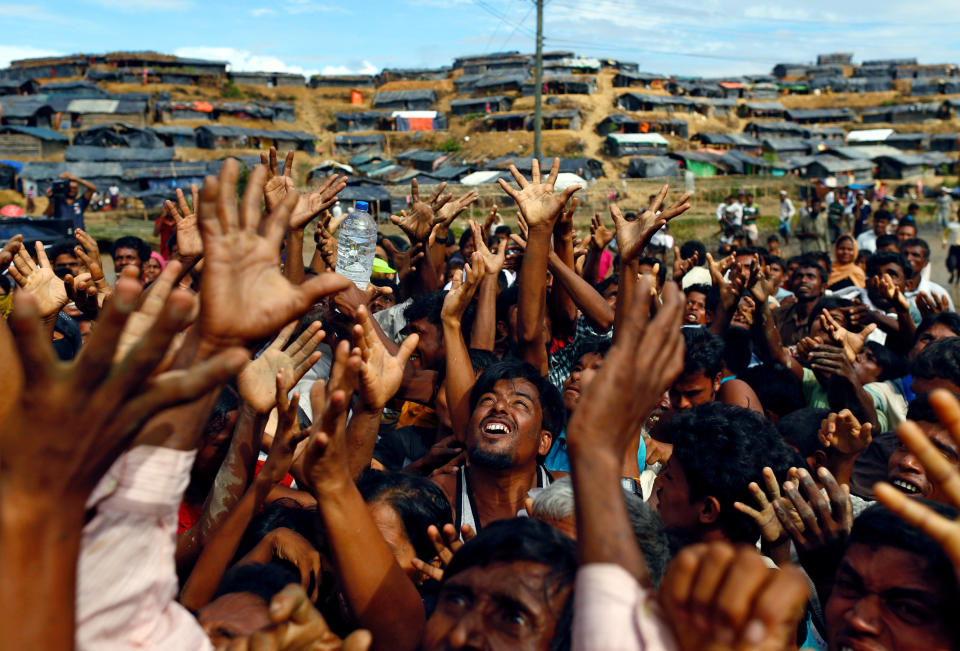 Rohingya refugees stretch their hands to receive aid distributed by local organizations at Balukhali makeshift refugee camp in Cox's Bazar, Bangladesh, on Sept. 14, 2017.