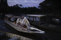 SOS Funeral workers transport by boat the coffin containing the body of a suspected COVID-19 victim that died in a river-side community near Manaus, Brazil on May 14, 2020. The victim, an 86-year-old woman, lived by the Negro river, the largest tributary to the Amazon river. (AP Photo/Felipe Dana)