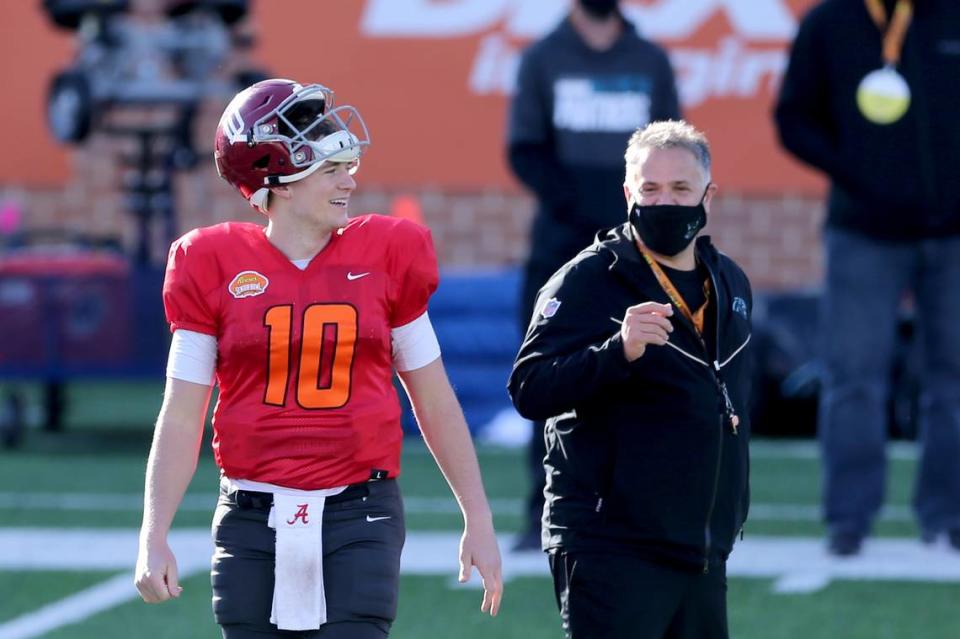 Quarterback Mac Jones of Alabama (10) shares a laugh with American Team head coach Matt Rhule (Carolina Panthers) during the American team practice for the NCAA college football Senior Bowl in Mobile, Ala, Thursday, Jan. 28, 2021. (AP Photo/Rusty Costanza)