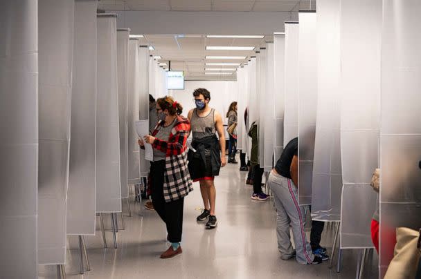 PHOTO: Residents of Cuyahoga county, separated by plastic due to health concerns amid the coronavirus pandemic, arrive to fill out paper ballots for early, in person voting at the board of elections office in downtown Cleveland, Oct. 16, 2020. (Dustin Franz/AFP via Getty Images)