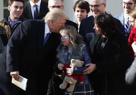 U.S. President Donald Trump greets a young girl among families gathered in the White House Rose Garden as he addresses the annual March for Life rally, taking place on the nearby National Mall in Washington, U.S., January 19, 2018. REUTERS/Kevin Lamarque