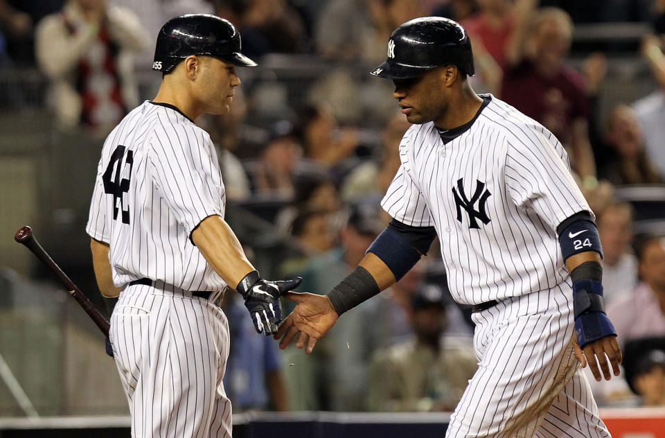 NEW YORK, NY - APRIL 15: Robinson Cano of the New York Yankees celebrates scoring a run with Russell Martin against the Los Angeles Angels of Anaheim at Yankee Stadium on April 15, 2012 in the Bronx borough of New York City. In honor of Jackie Robinson Day, all players across Major League Baseball will wear number 42. (Photo by Nick Laham/Getty Images)