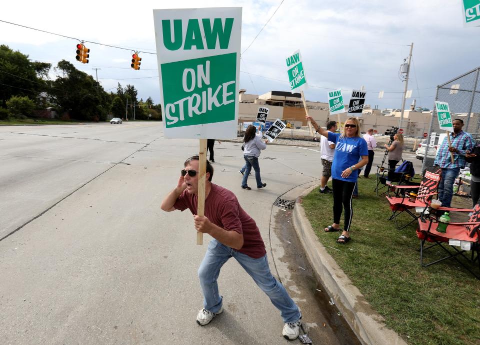 Jack Barber, 57, of Clio leans out looking to get honks from passing cars for support as he and other UAW members from Locals 598 and 659 strike prior to the union leadership authorizing the autoworker strike in front of the General Motors Flint Assembly plant in Flint, Michigan on Sunday, September 15, 2019.