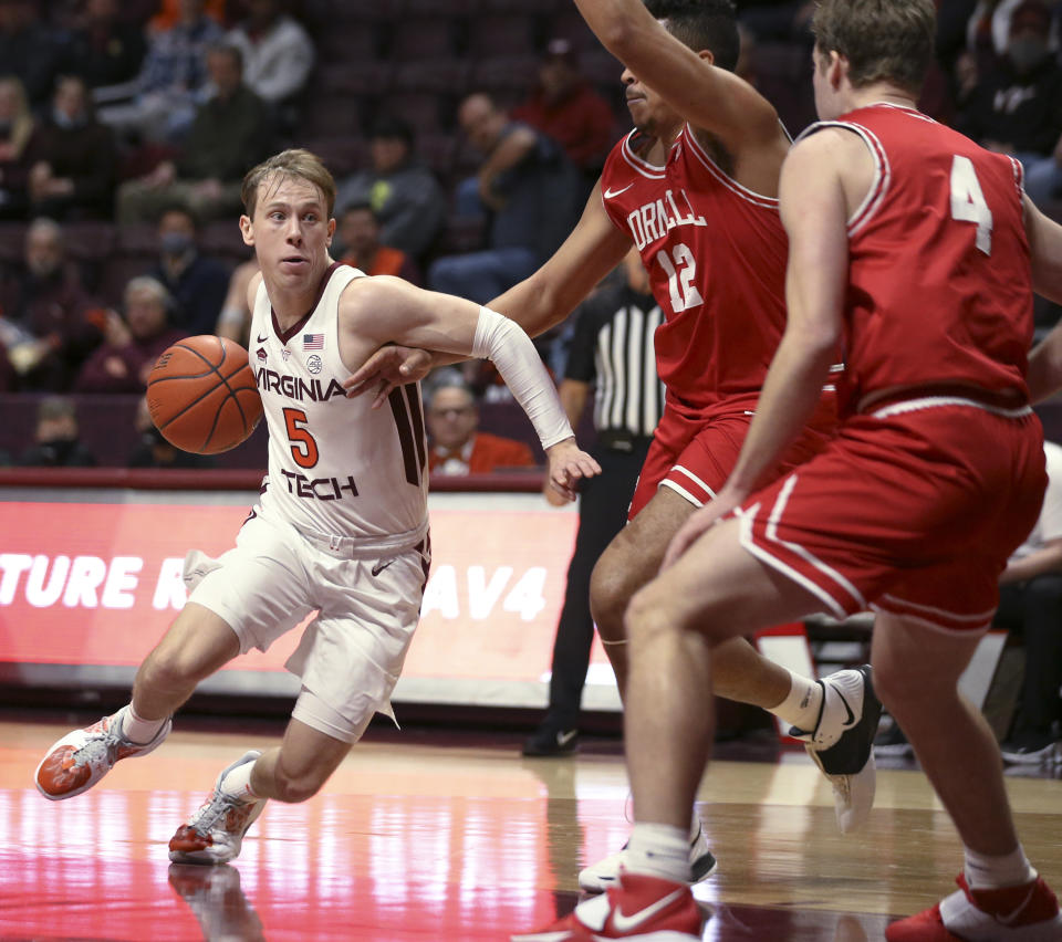 Virginia Tech's Storm Murphy (5) drives while defended by Cornell's Kobe Dickson (12) and Greg Dolan (4) during the first half of an NCAA college basketball game Wednesday, Dec. 8 2021, in Blacksburg, Va. (Matt Gentry/The Roanoke Times via AP)