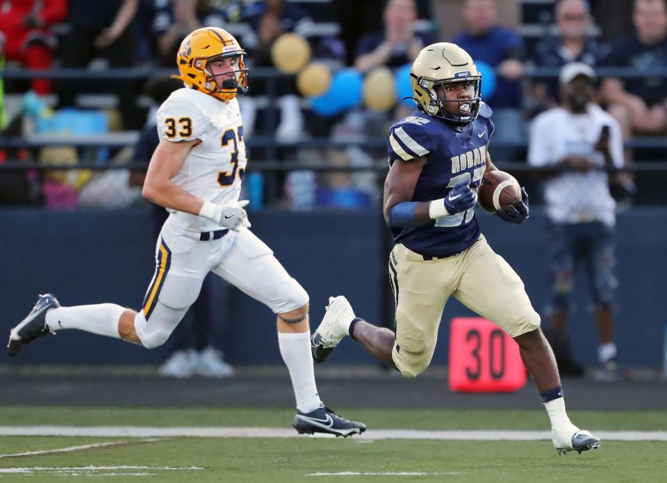 Hoban running back Lamar Sperling rushes 83 yards to score ahead of St. Ignatius defensive back Christian Cupp during the first half of a high school football game, Friday, Sept. 16, 2022, in Akron, Ohio.