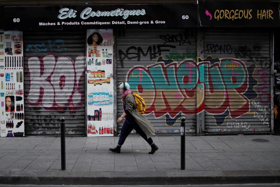 A woman walks past a closed hair and cosmetic shop in Paris during France’s second national lockdown (REUTERS)