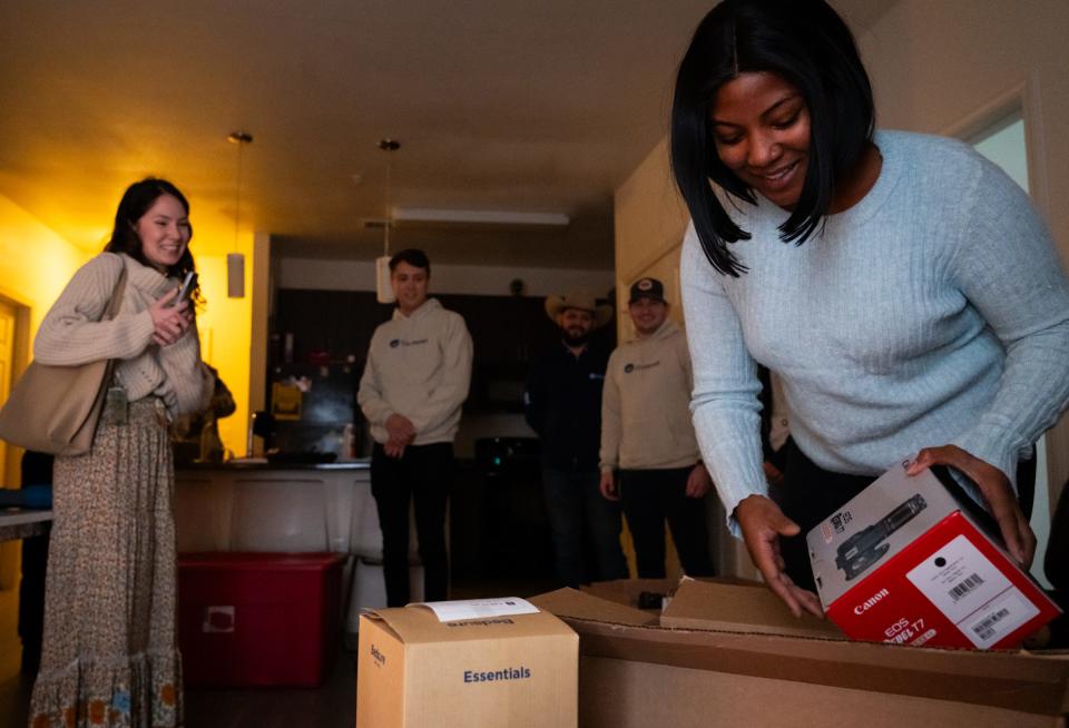 Aaliyah Gaulmon opens a camera given by Ownwell as representatives from the company drop off gifts for Gaulmon and her 4-year-old daughter. The family had experienced homelessness before they connected with Caritas of Austin.