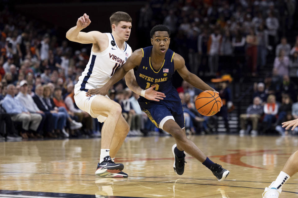 Notre Dame's Marcus Hammond (10) dribbles past Virginia's Isaac McKneely (11) during the first half of an NCAA college basketball game in Charlottesville, Va., Saturday, Feb. 18, 2023. (AP Photo/Mike Kropf)