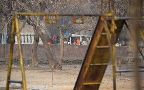 A vehicle burns near a playground next to an office of the British charity Save the Children - Credit: NOORULLAH SHIRZADA /AFP
