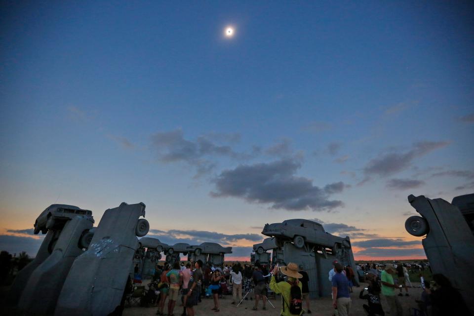 The total solar eclipse darkens the sky over Carhenge in  Alliance, Neb. on Aug. 21, 2017