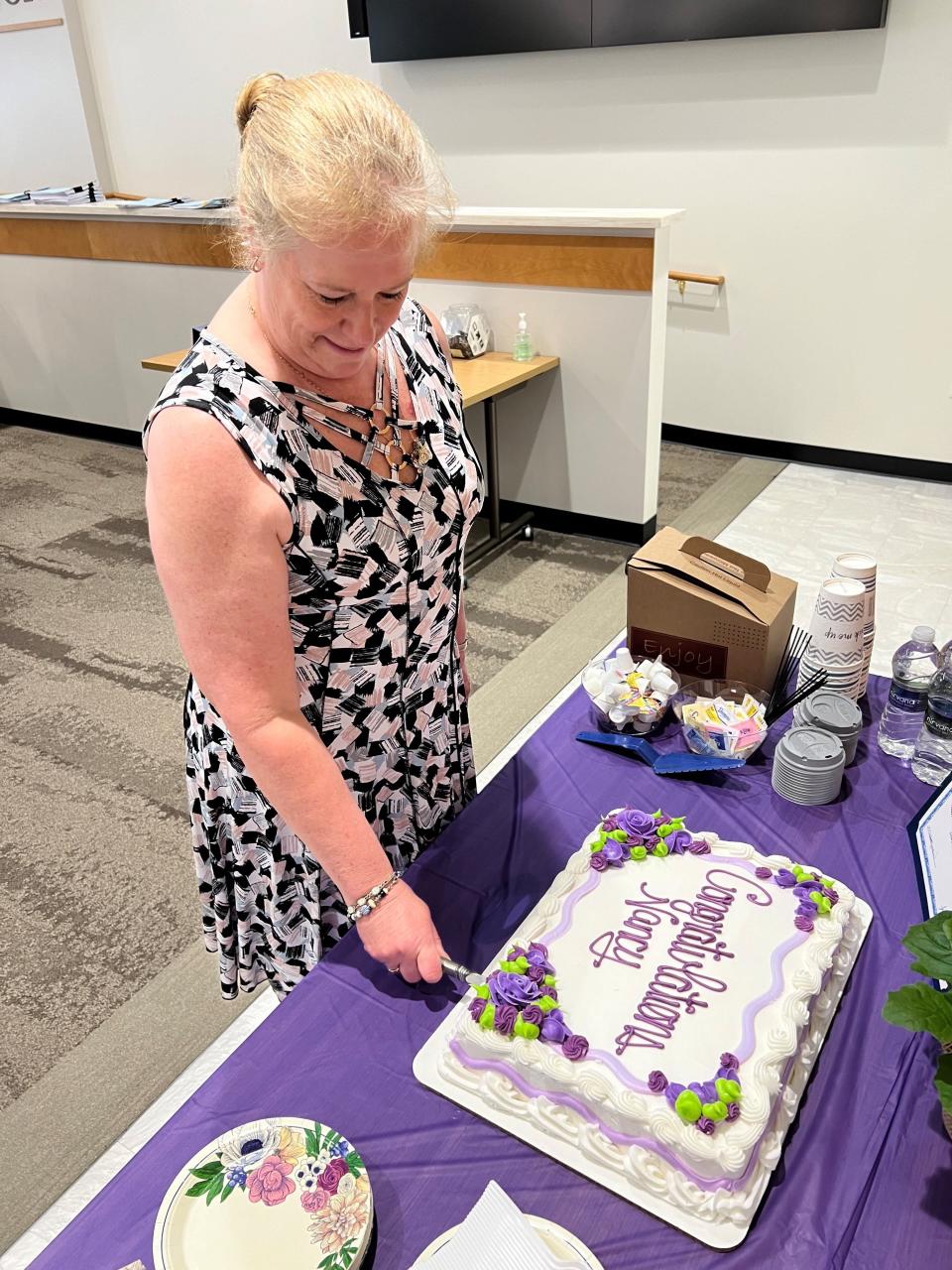 Nancy Nicholl cuts a congratulatory cake after she was presented with the Oneida County Older American Award at a ceremony on May 16, 2024 in the Oneida County Office Building in Rome.