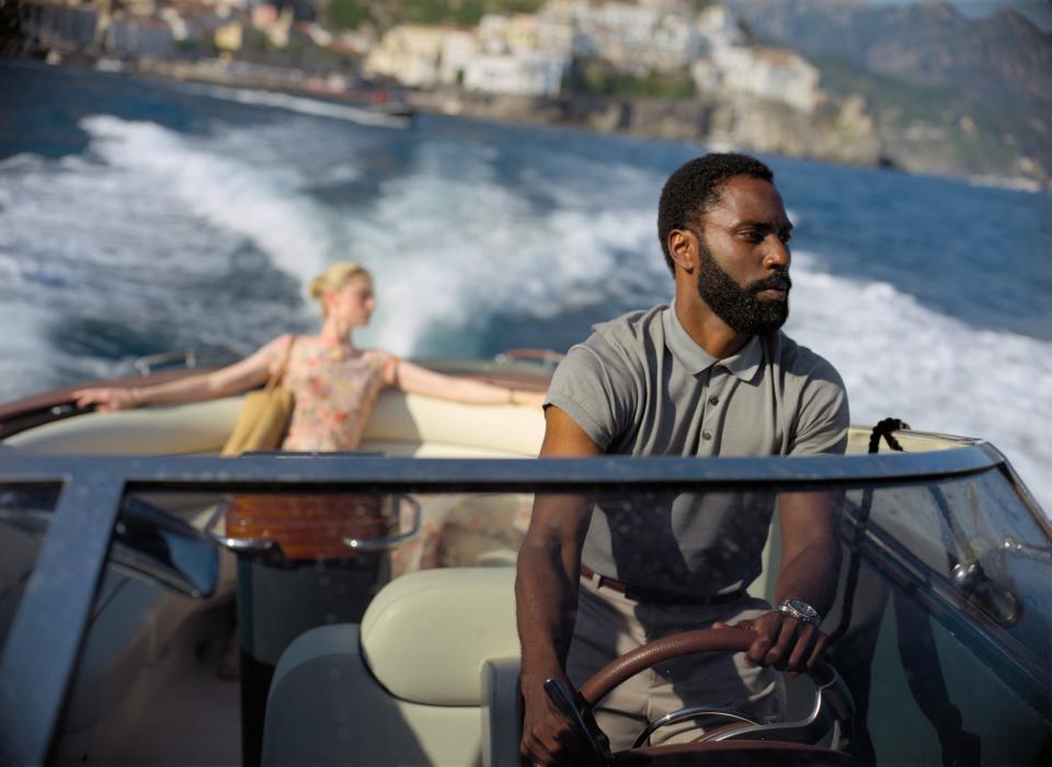 a man driving a boat while a woman sits in the back