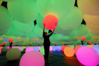 A visitor plays with balloon during a digital art exhibition titled teamLab Future Park and Animals of Flowers, Symbiotic Lives, at a shopping mall in Jakarta, Indonesia, Wednesday, June 19, 2019. The exhibition that showcase the creation of teamLab, a Japanese digital art company, will be held from June to December 2019. (AP Photo/Tatan Syuflana)