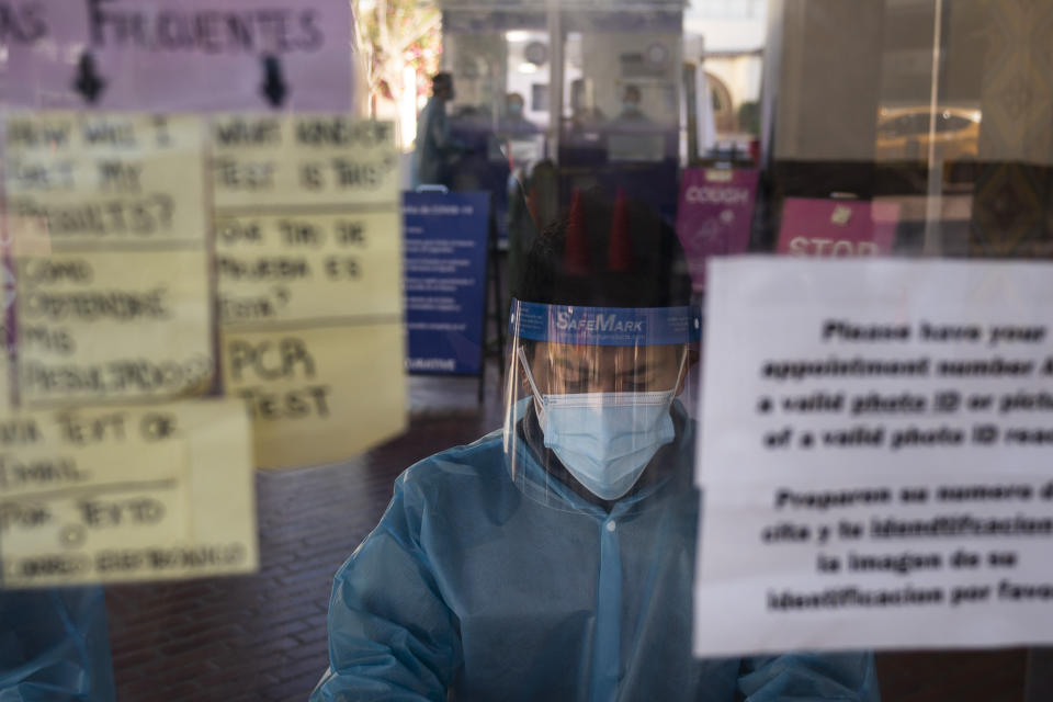 FILE - In this Dec. 9, 2020, file photo, test specialist Lester Gopar works at a COVID-19 testing site in Los Angeles. As officials met to discuss approval of a COVID-19 vaccine on Thursday, Dec. 10, the number of coronavirus deaths has grown bleaker than ever. (AP Photo/Jae C. Hong, File)