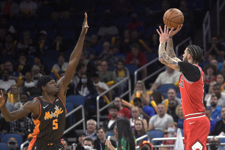 Chicago Bulls guard Lonzo Ball, right, shoots a three-point basket in front of Orlando Magic center Mo Bamba (5) during the first half of an NBA basketball game, Friday, Nov. 26, 2021, in Orlando, Fla. (AP Photo/Phelan M. Ebenhack)