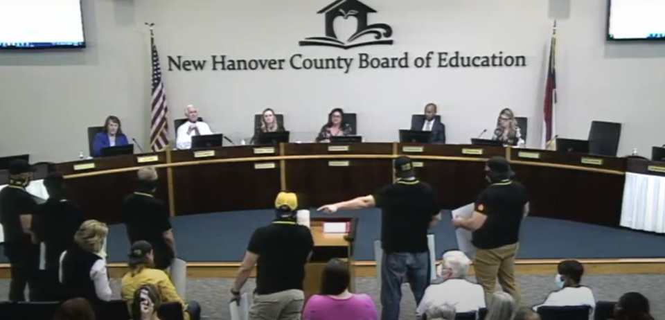 A group of Proud Boys confront school board Chairwoman Stephanie Kraybill after some confusion rose around the order of speakers during a public comment session at a New Hanover County Board of Education meeting April 5, 2022.