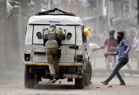 Demonstrators try to hurl stones at an Indian police vehicle during a protest in Srinagar against the recent killings in Kashmir, August 30, 2016. REUTERS/Danish Ismail/File Photo