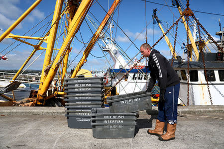 FILE PHOTO: A worker loads boxes at a port in Newlyn, Britain August 9, 2017. REUTERS/Neil Hall/File Photo